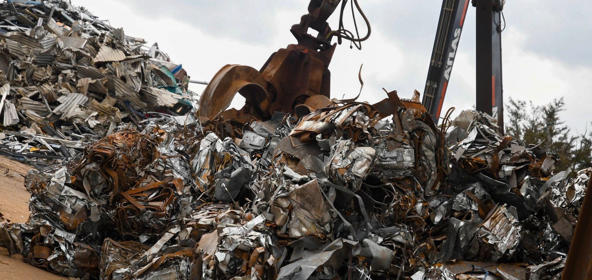 A pile of scrap metal is being picked up by a claw at Benfleet Scrap