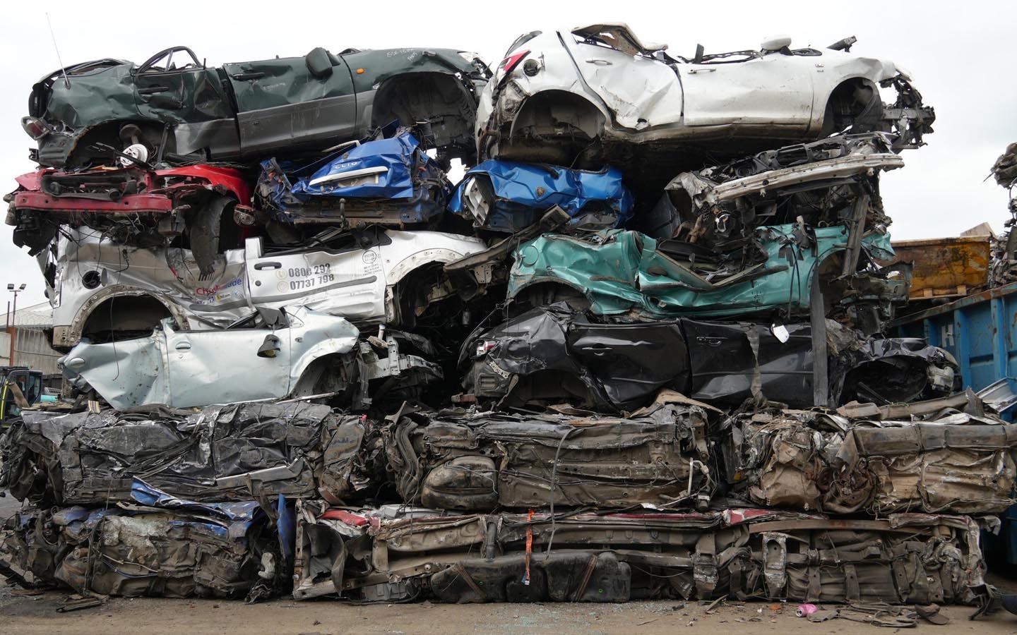 A pile of scrap cars stacked on top of each other in Benfleet Scrap yard.