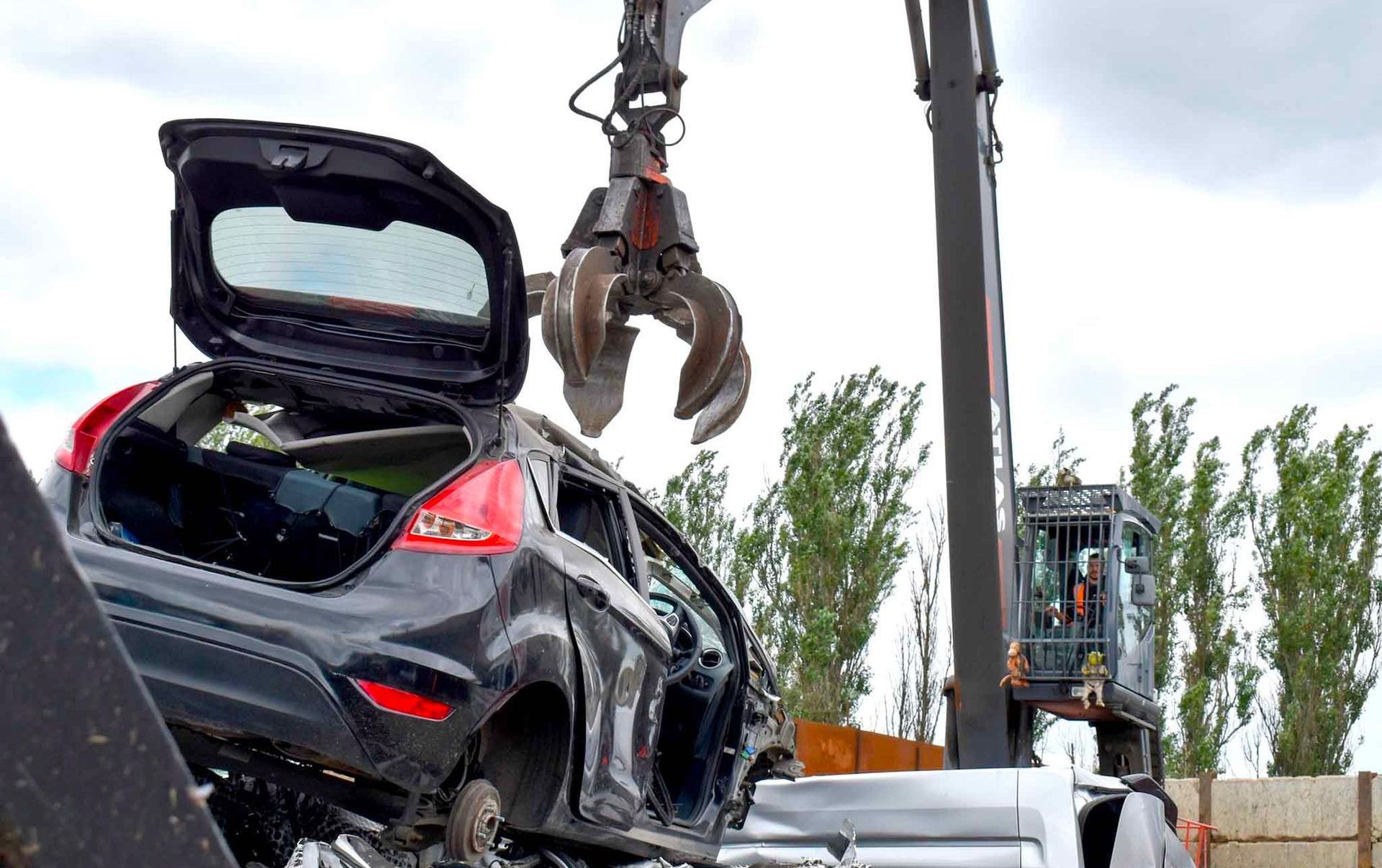 A scrap car is being dismantled by a claw at Benfleet Scrap