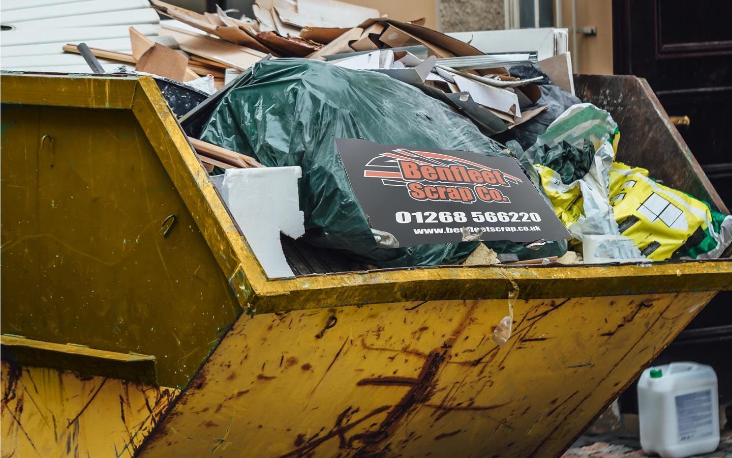 A large yellow skip filled with household rubble