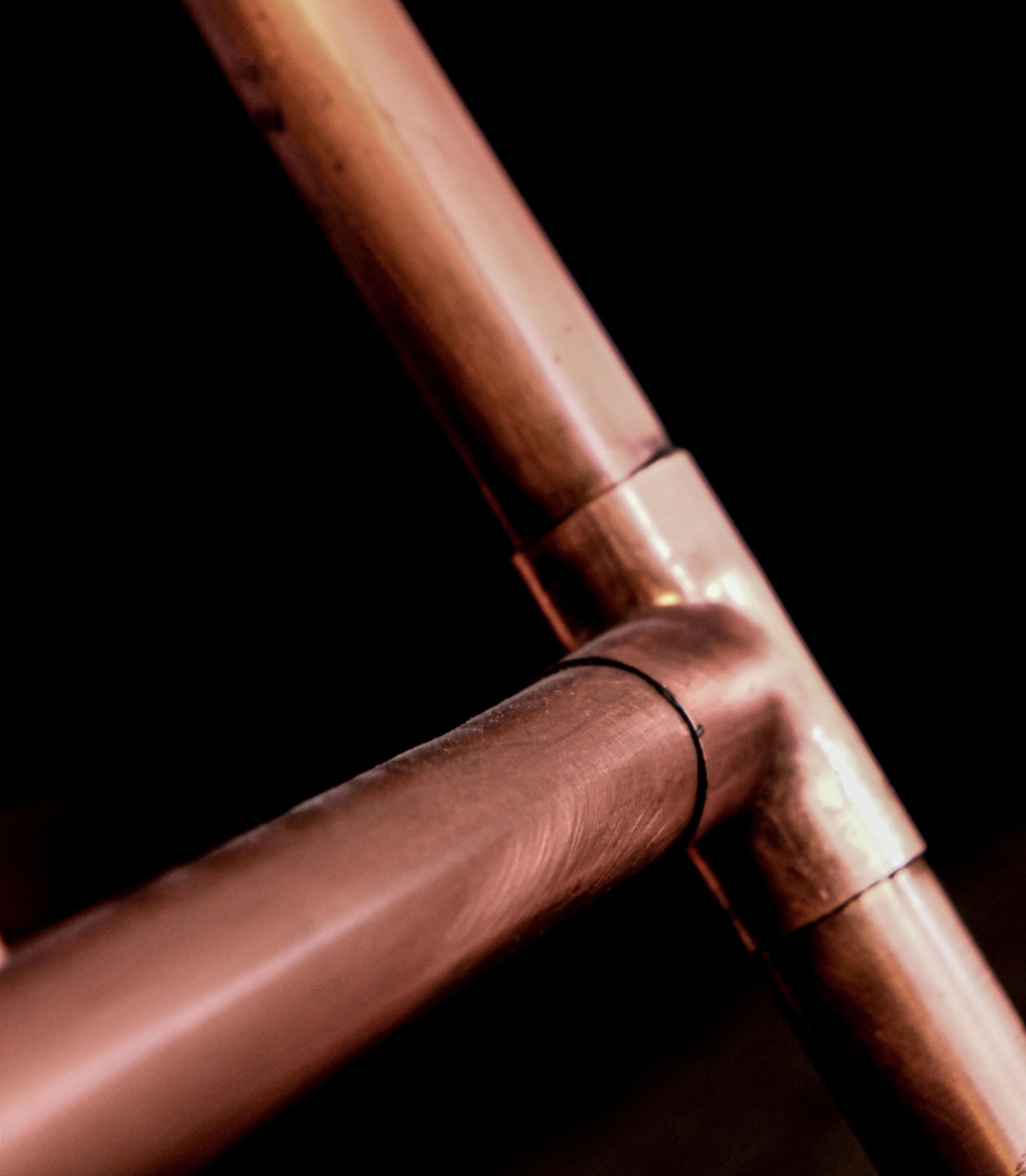 A close up of a copper pipe on a black background