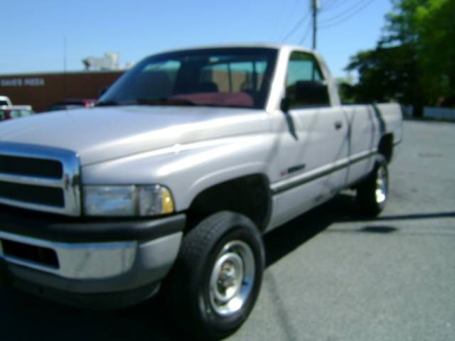 A white dodge ram truck is parked in a parking lot