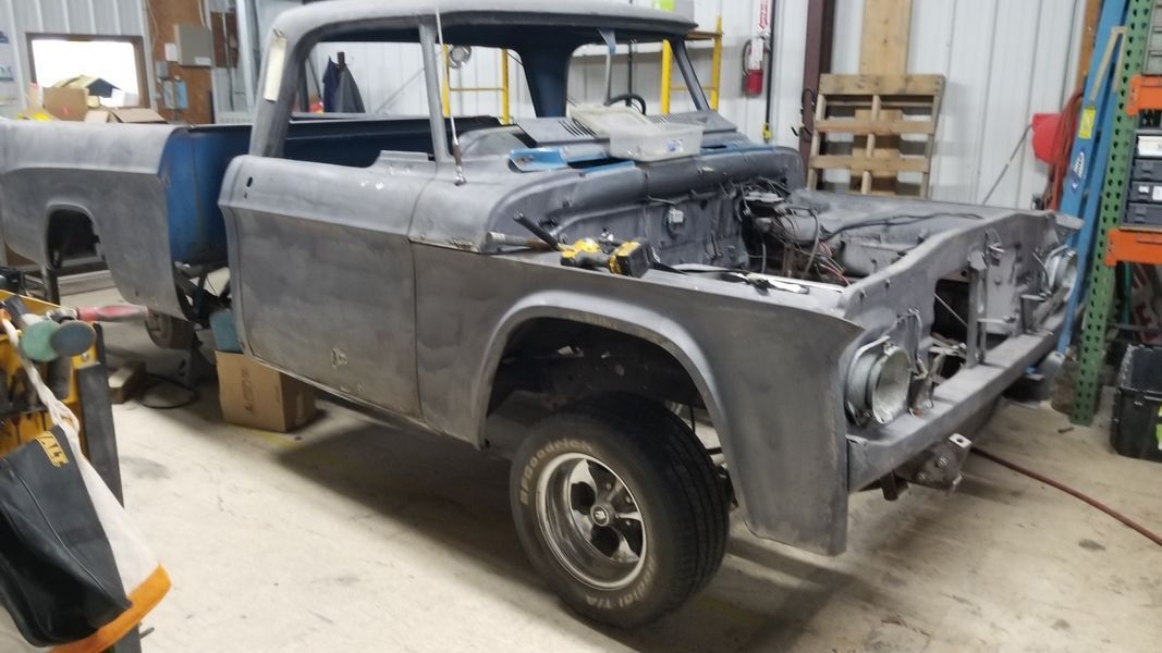A truck is being restored in a garage.