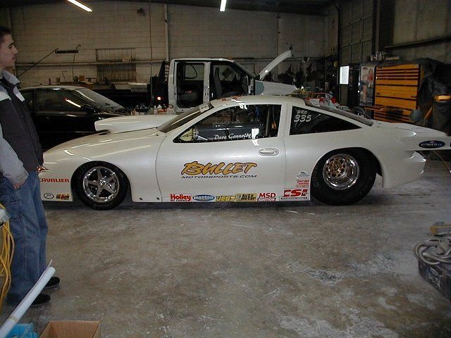 A man stands next to a white race car