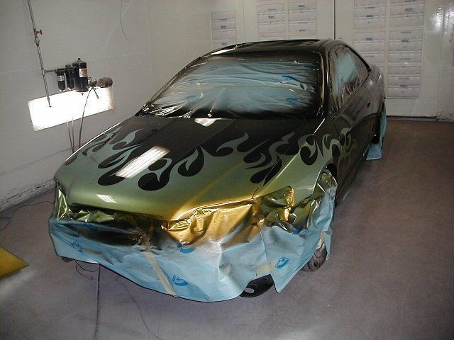 A green car with flames painted on the hood