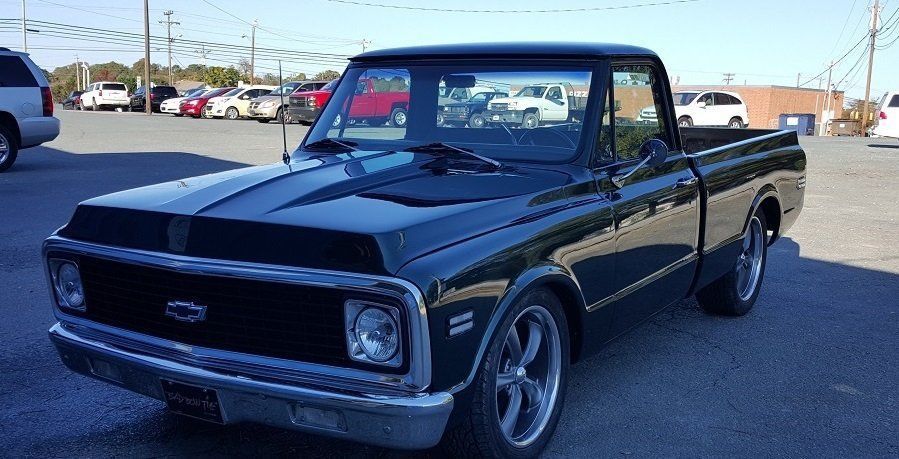 A black chevrolet truck is parked in a parking lot.