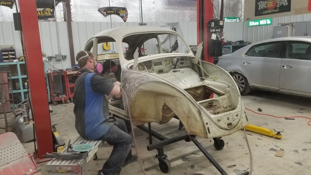 A man is working on a car in a garage.