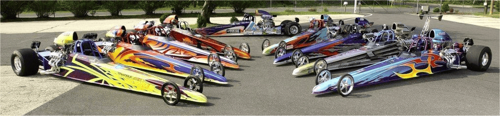 A group of drag racing cars are lined up on a track