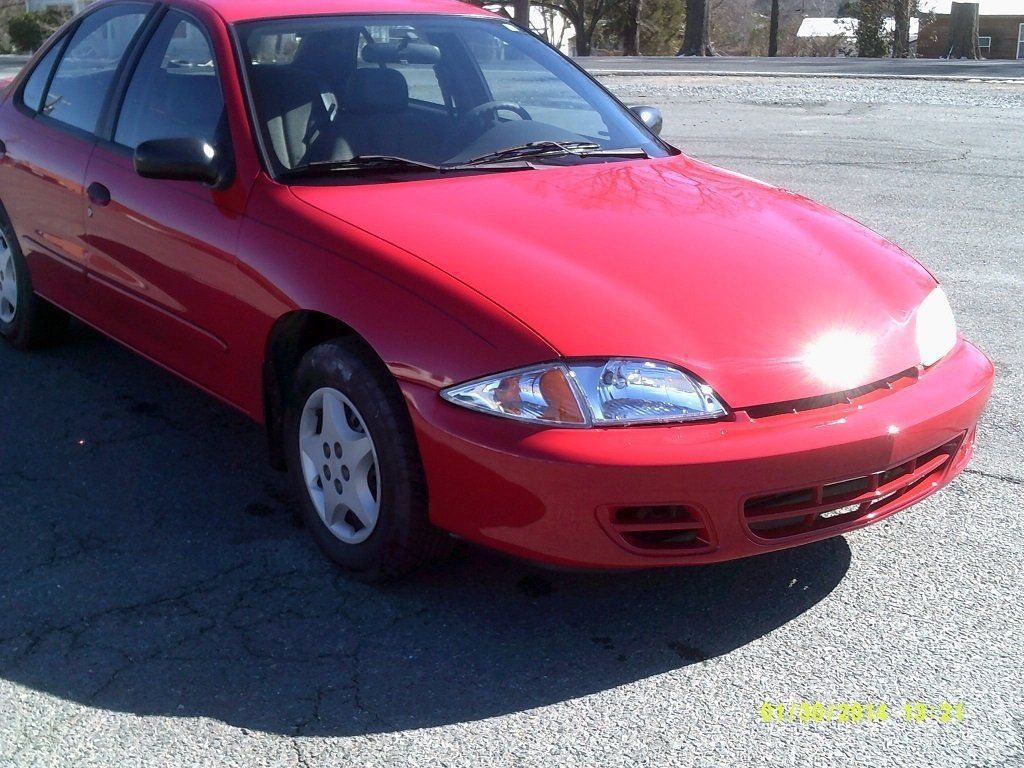A red car is parked on the side of the road