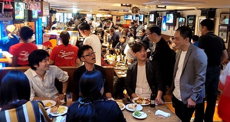 Crowded bar: People drinking, eating, and talking, in a lively setting.