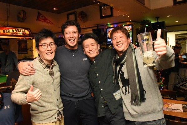 若い男性のグループが写真のポーズをとっており、そのうちの1人が親指を立てています。