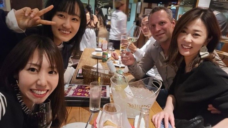 A group of people are sitting at a table at Shooters Sports Bar & Grill in Nagoya, Japan.