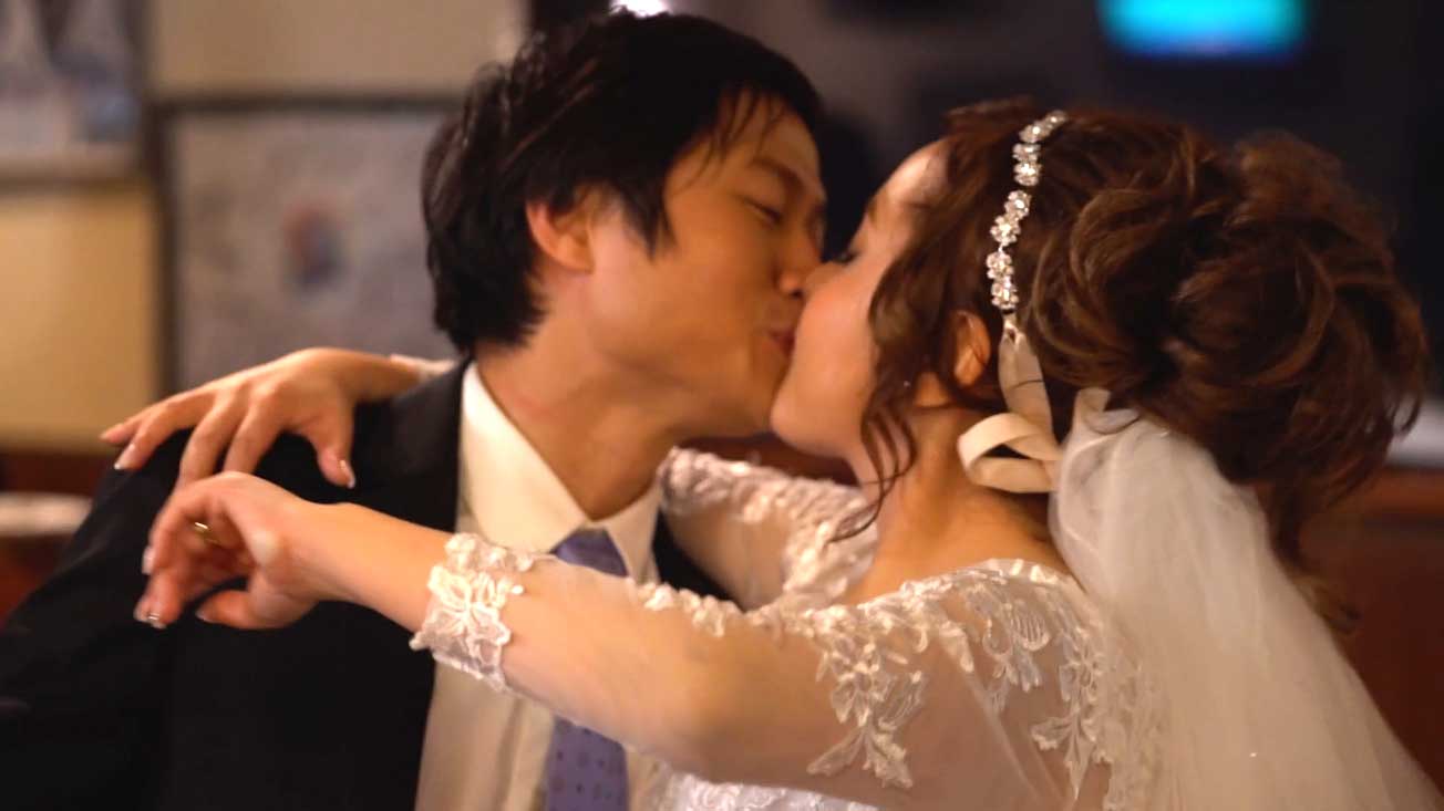 A bride and groom are kissing on their wedding day.