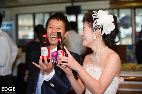 名古屋で行われた結婚式の二次会で、新郎新婦がビールのボトルを使って乾杯している