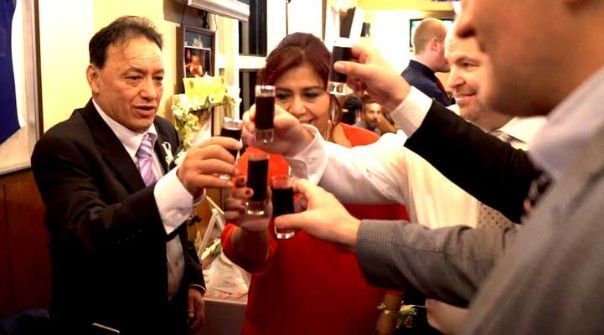 A group of people are toasting with shot glasses at a party venue in Nagoya.