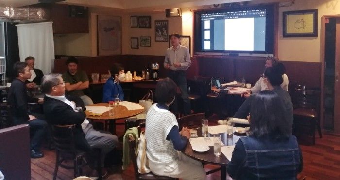 A group of people are watching a presentation in a restaurant