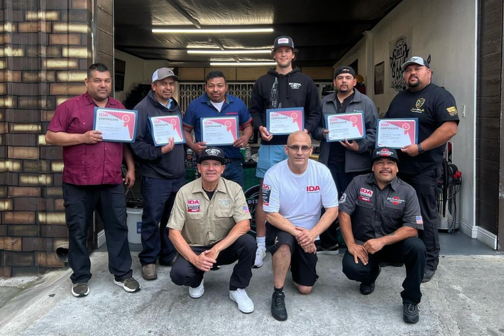 A group of men are posing for a picture while holding certificates.