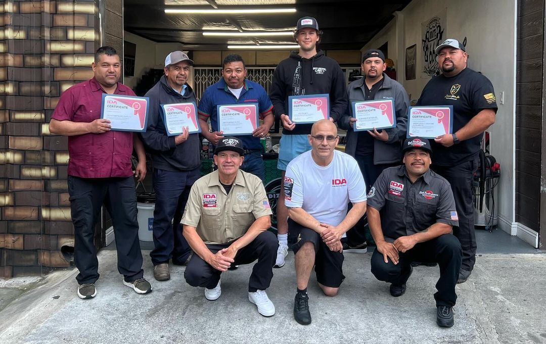A group of men are posing for a picture while holding certificates.