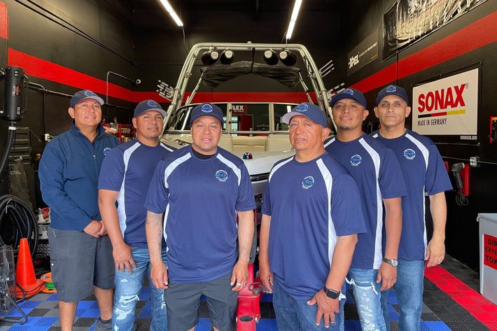 A group of men are posing for a picture in a garage.