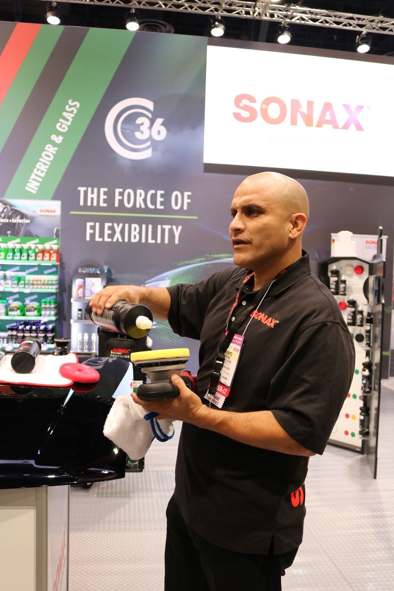 A man is standing in front of a sign that says sonax
