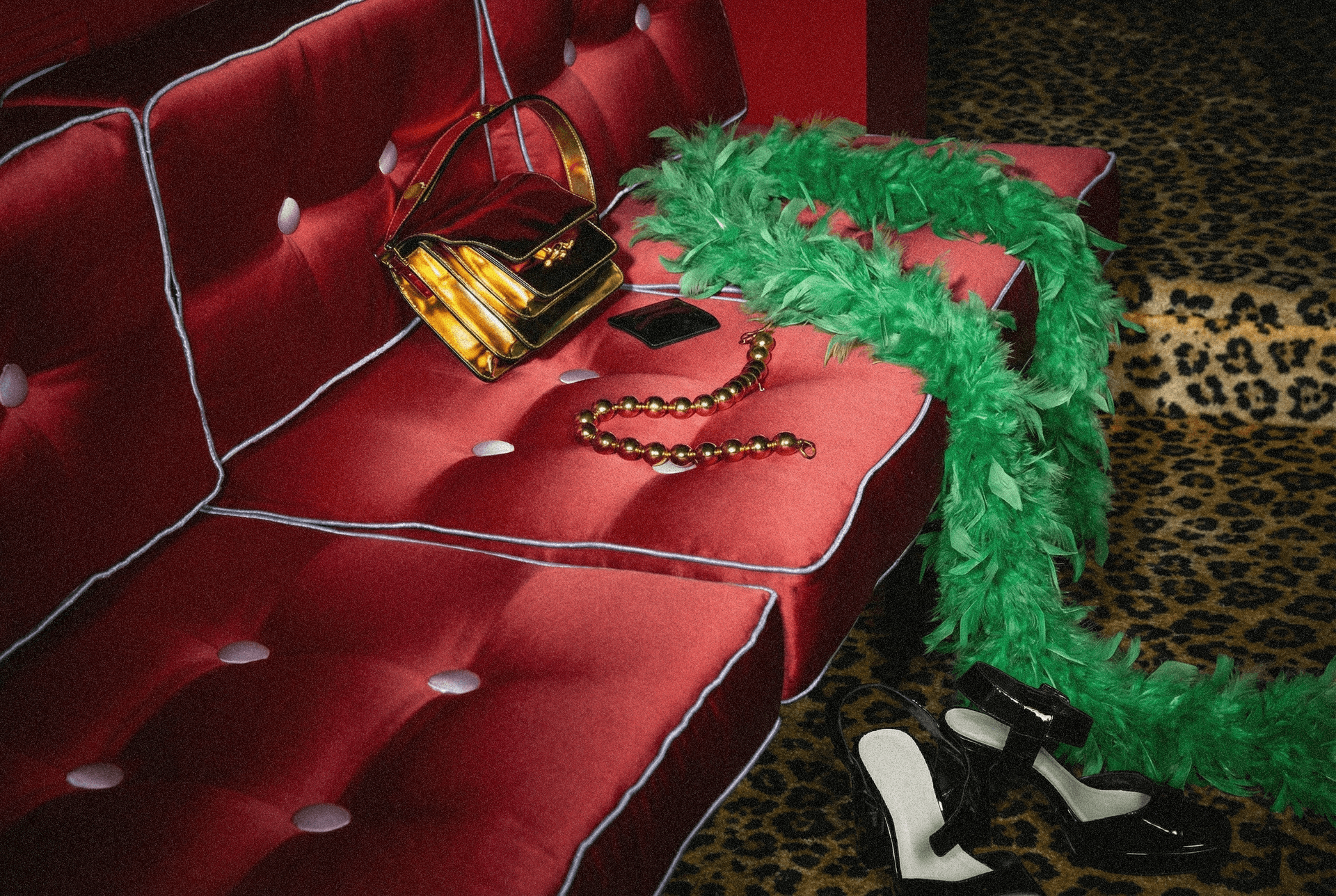 Green feather boa on red sofa