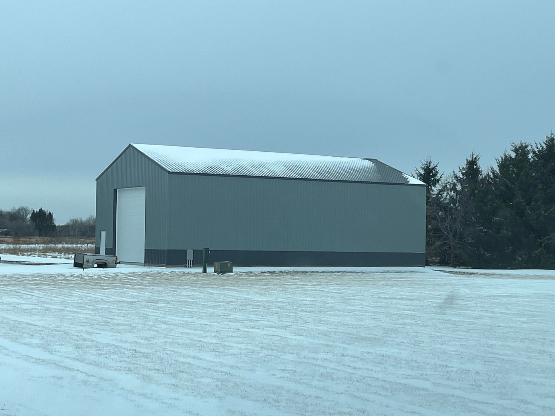 A large building is sitting in the middle of a snowy field.