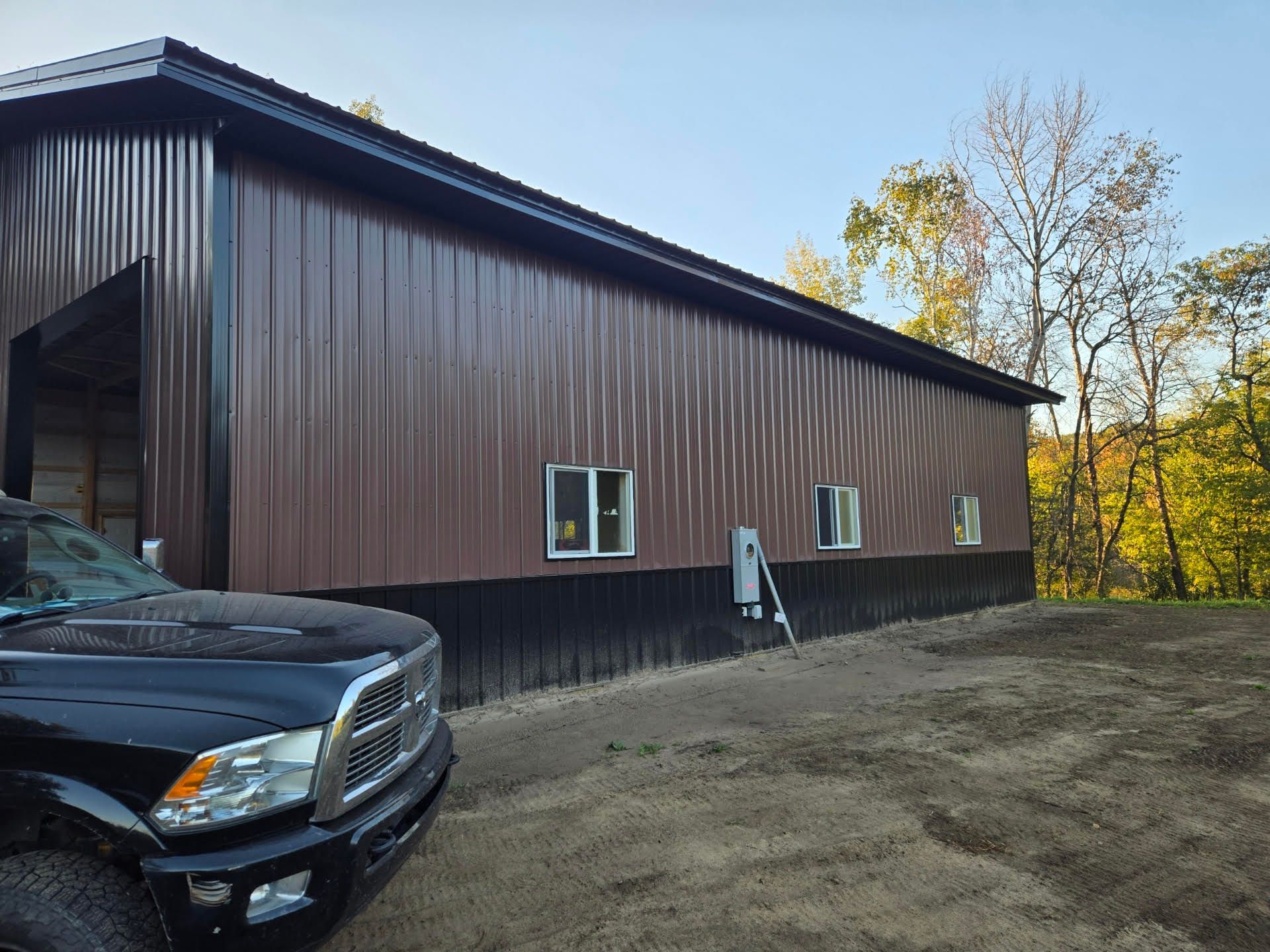 A black truck is parked in front of a brown building.