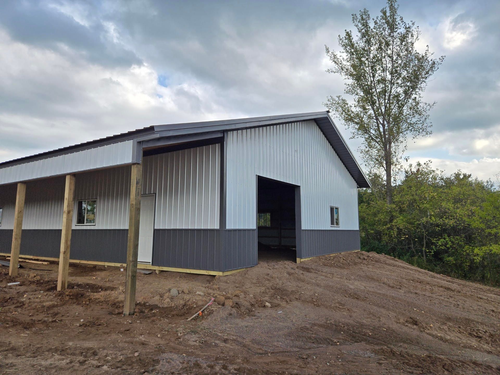 A large metal building is sitting on top of a dirt hill.