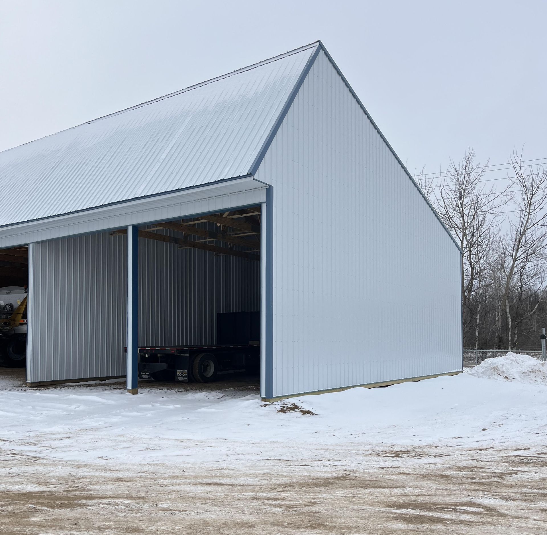 A white building with a roof that is covered in snow