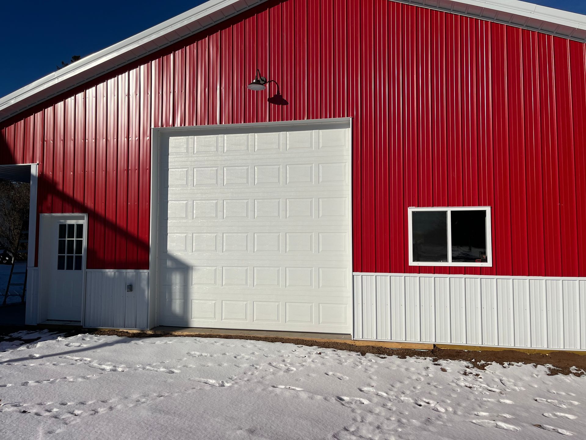A red barn with white trim and a white garage door
