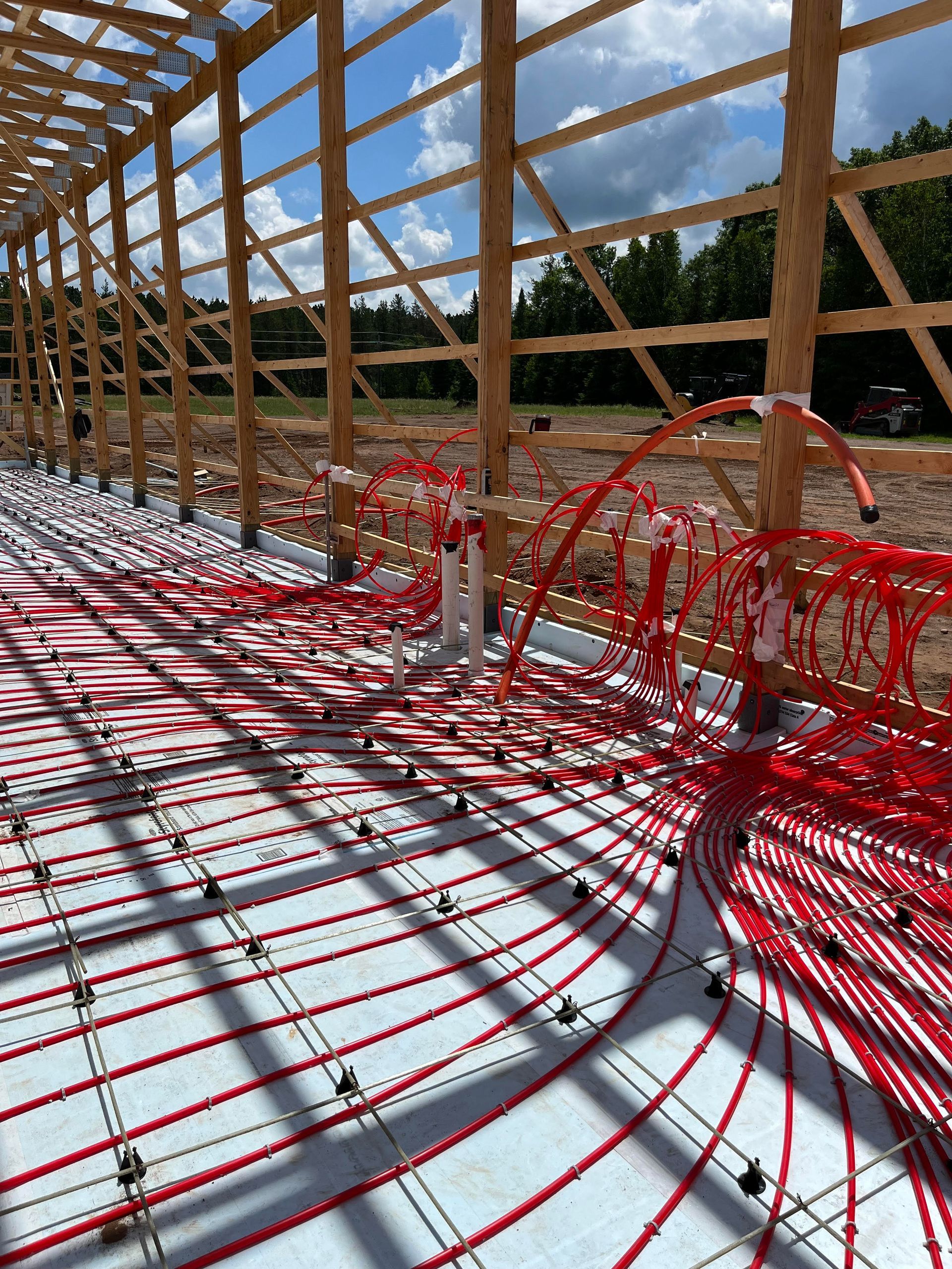 A large building under construction with a lot of red wires on the floor.