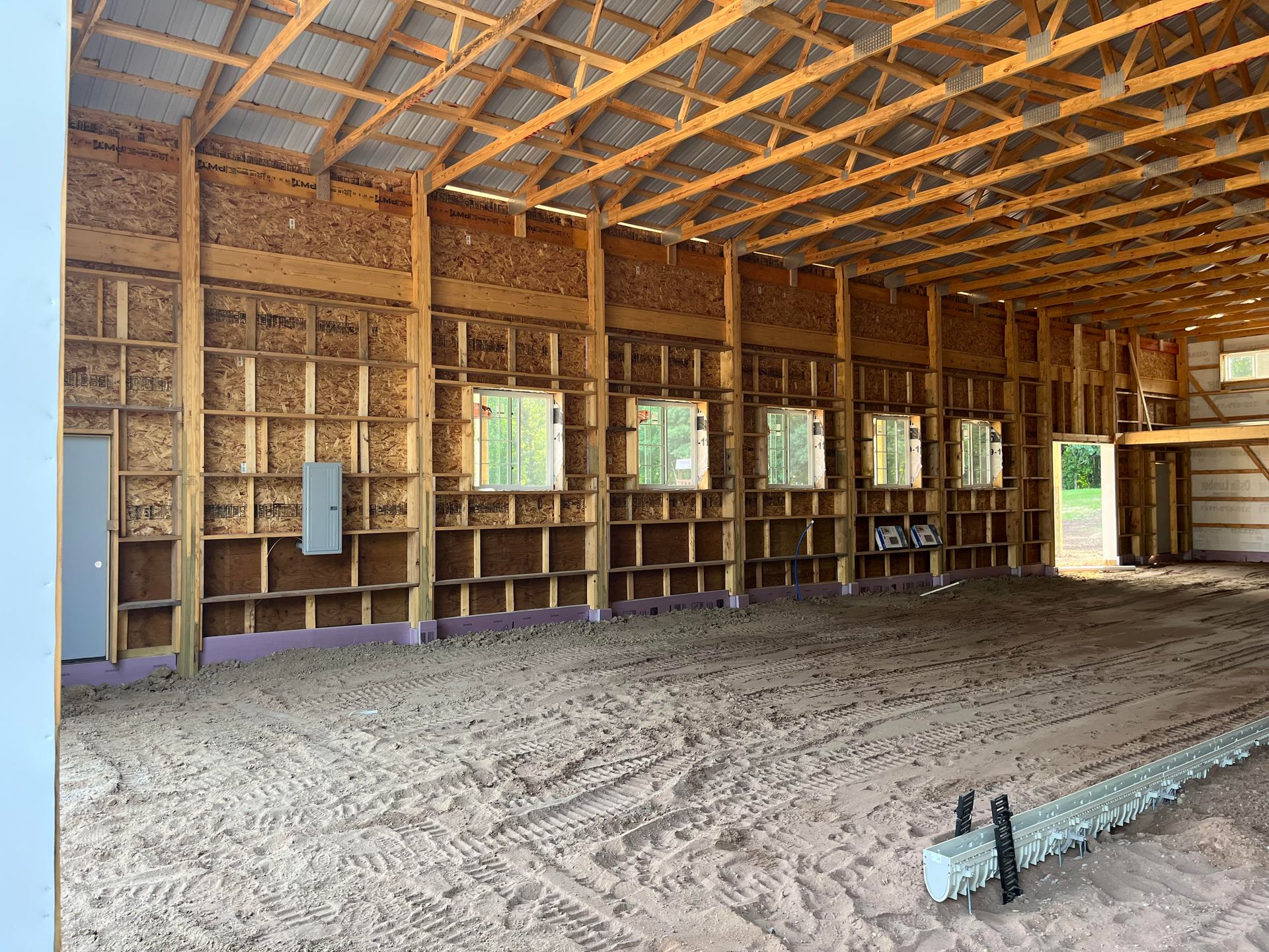 A large empty barn with a lot of windows and wooden beams.