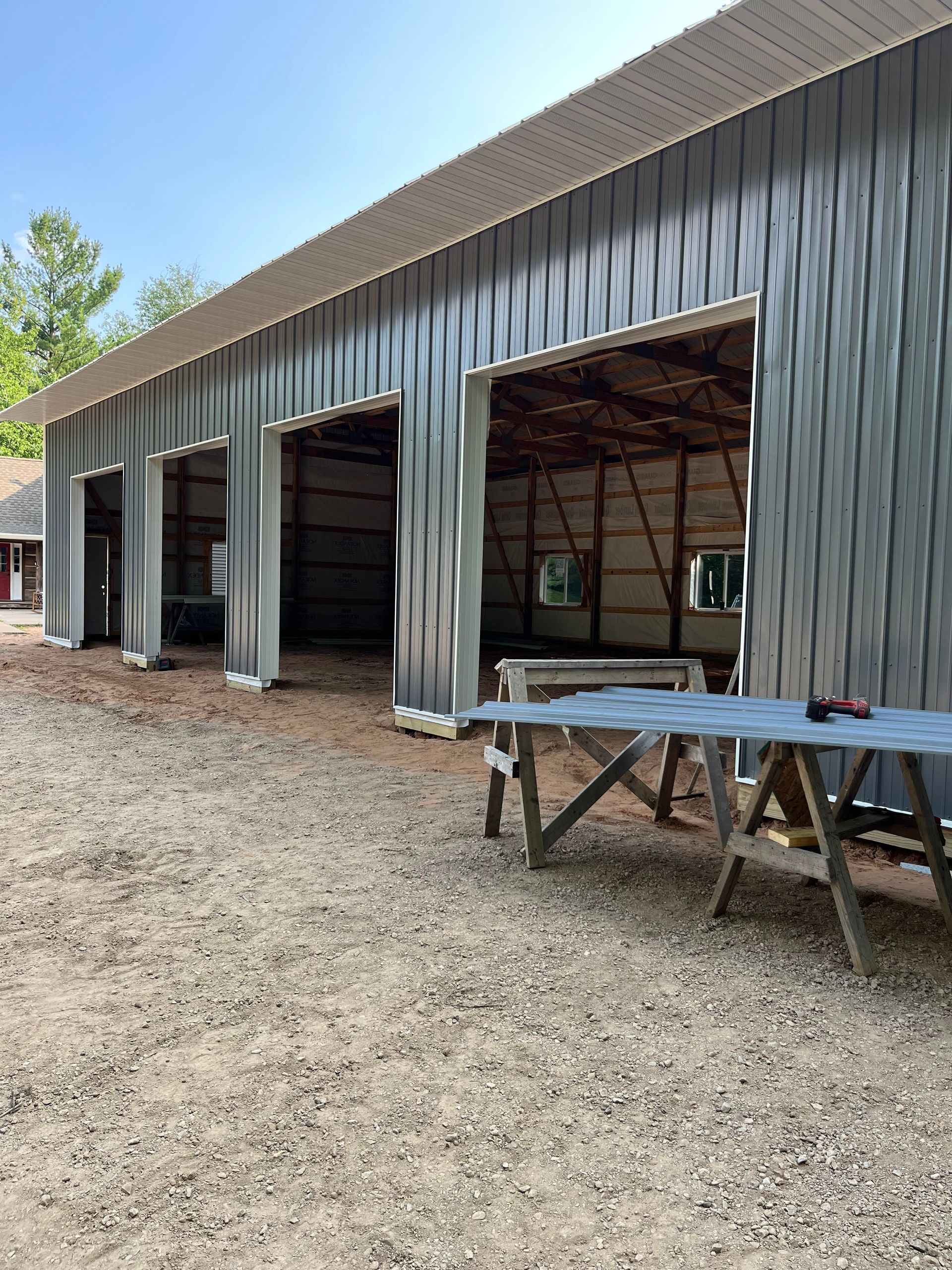 A picnic table is sitting in front of a building with its doors open.