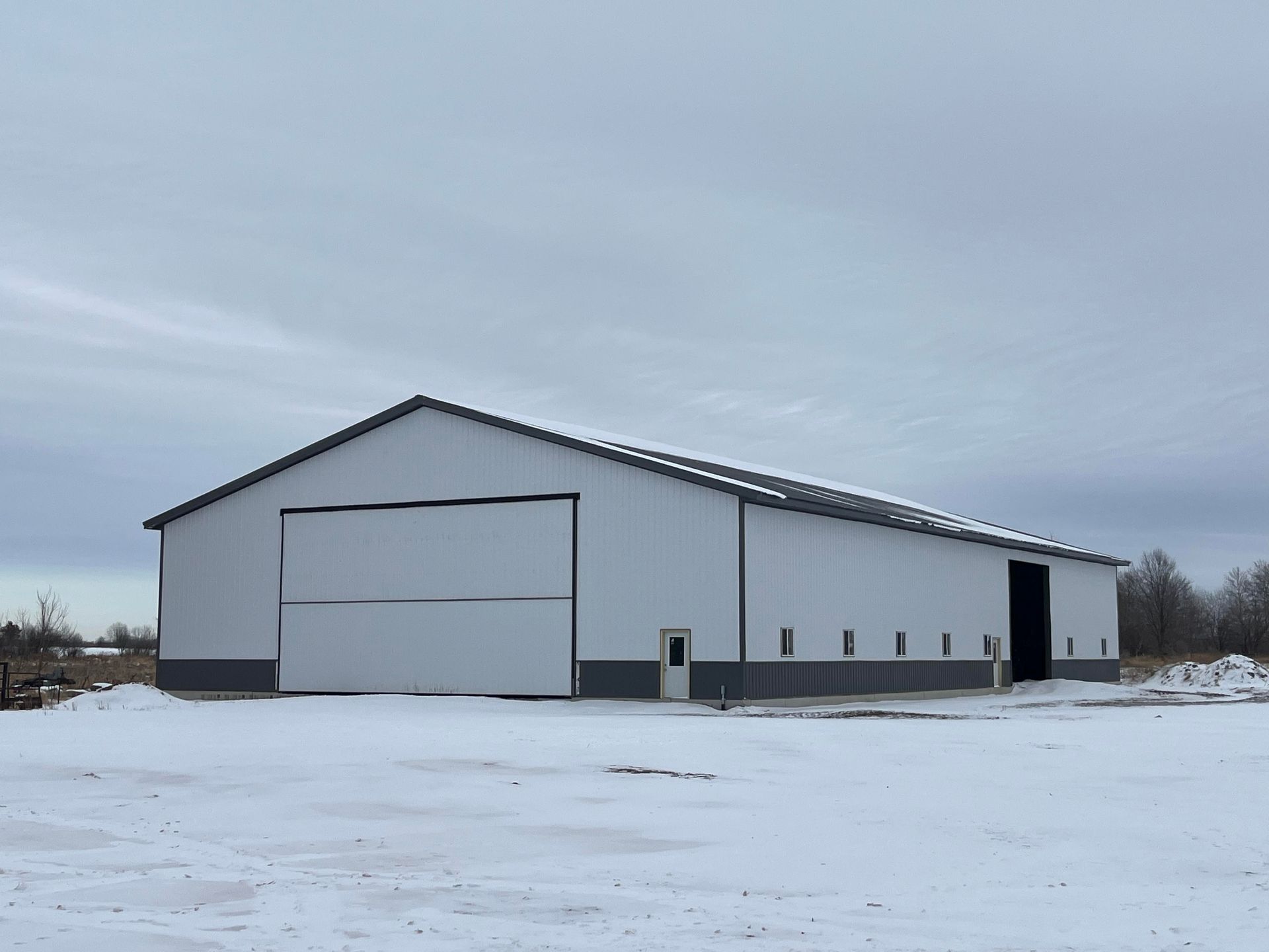 A large white building in the middle of a snowy field