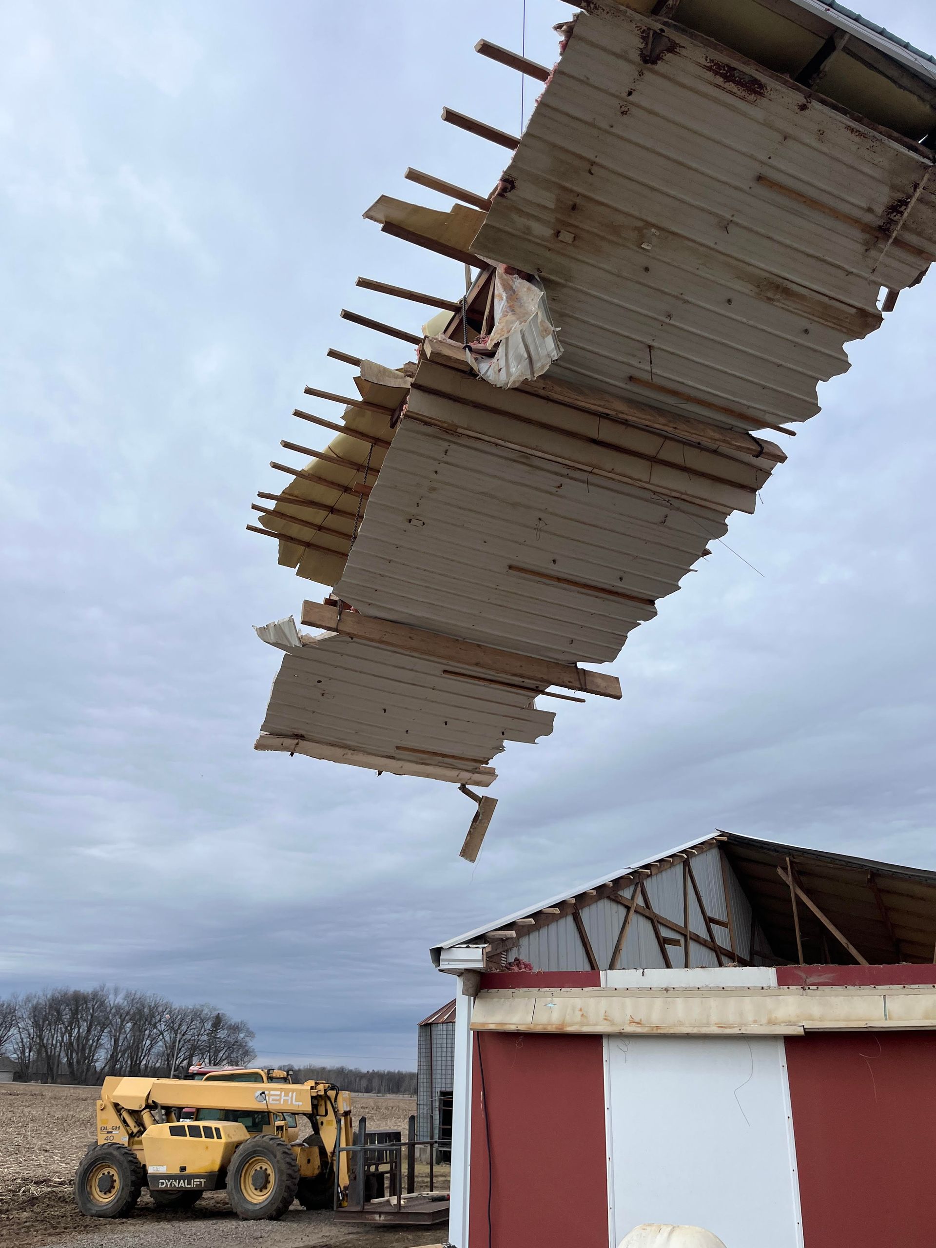 A large piece of wood is falling from the roof of a building