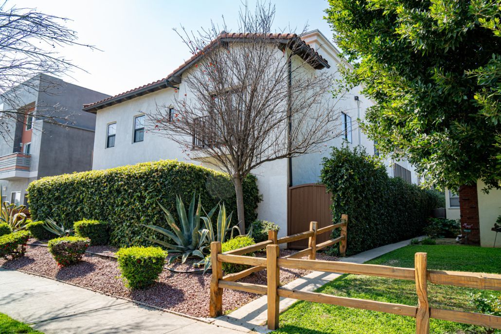 A white house with a wooden fence in front of it.