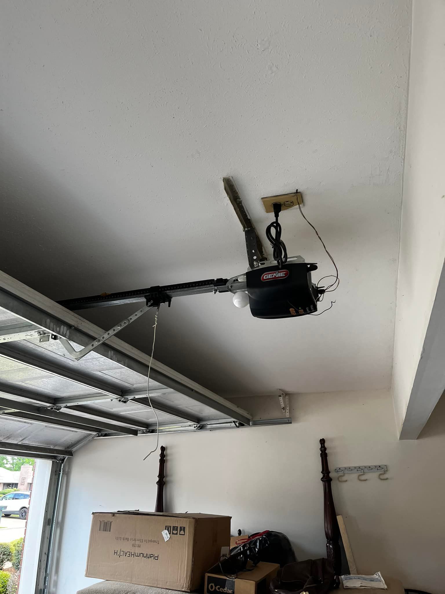 A garage door opener is hanging from the ceiling of a garage.