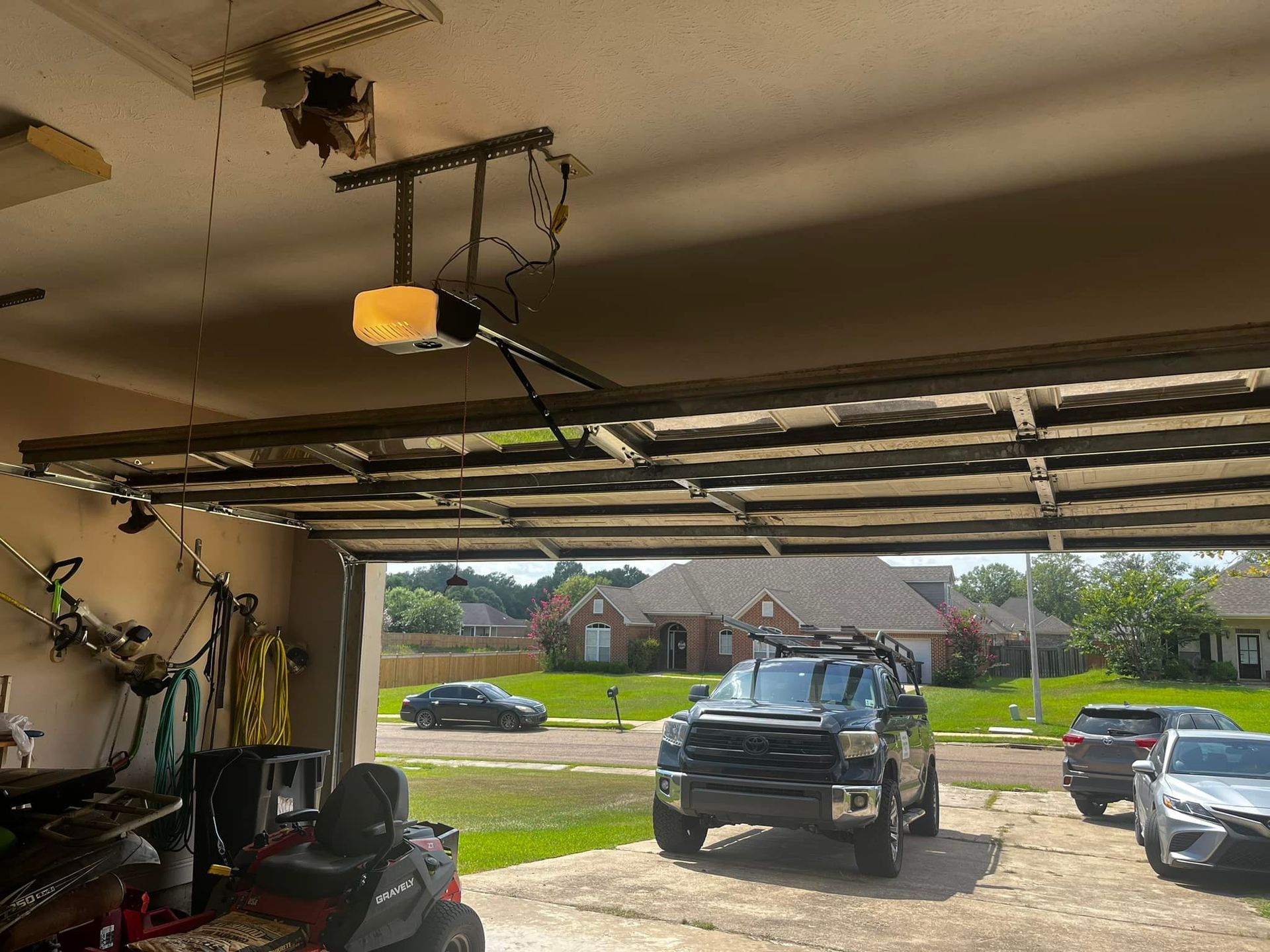 A truck is parked in a garage with a garage door open.
