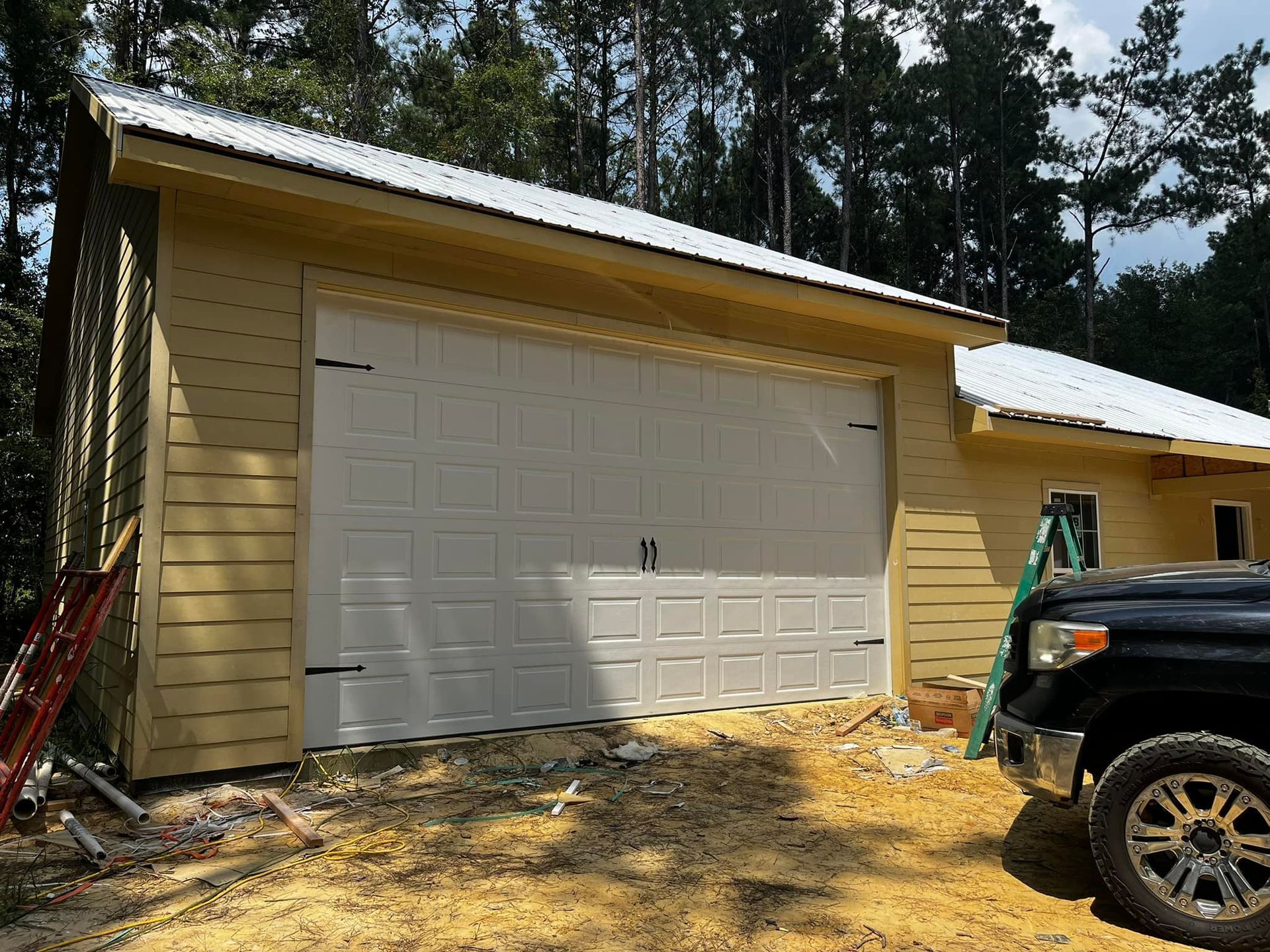 A truck is parked in front of a garage under construction.
