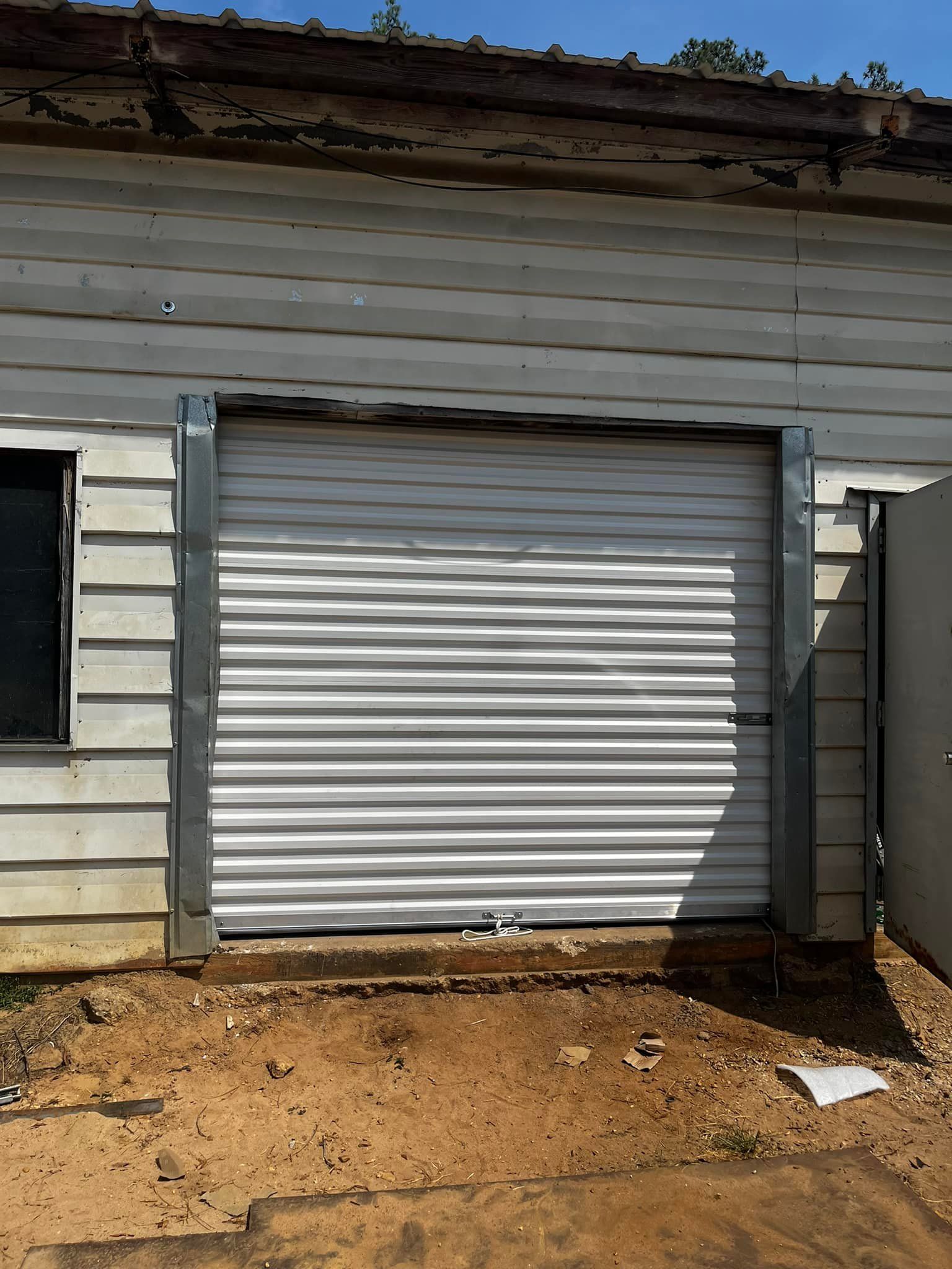 A white garage door is sitting on the side of a building.