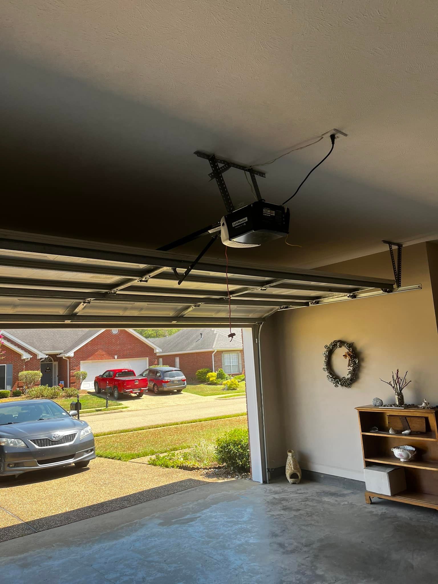 A garage with a car parked in it and a garage door open.