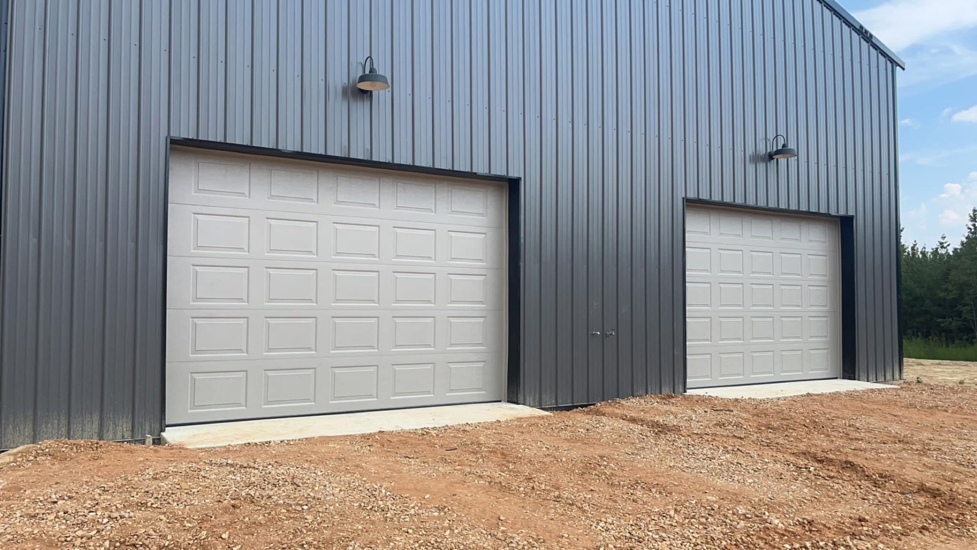 There are two garage doors on the side of a building.