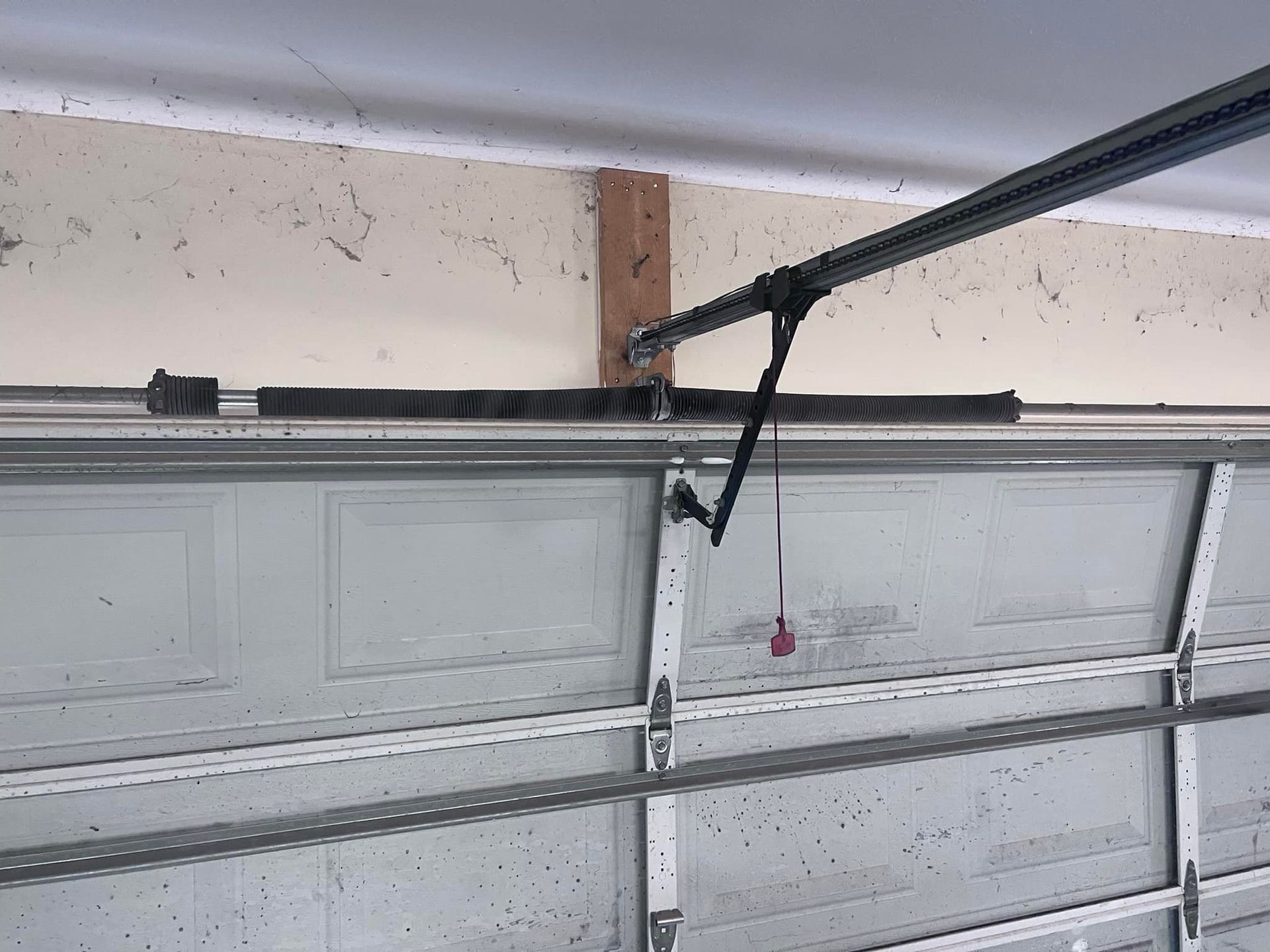A close up of a garage door with a broken spring.