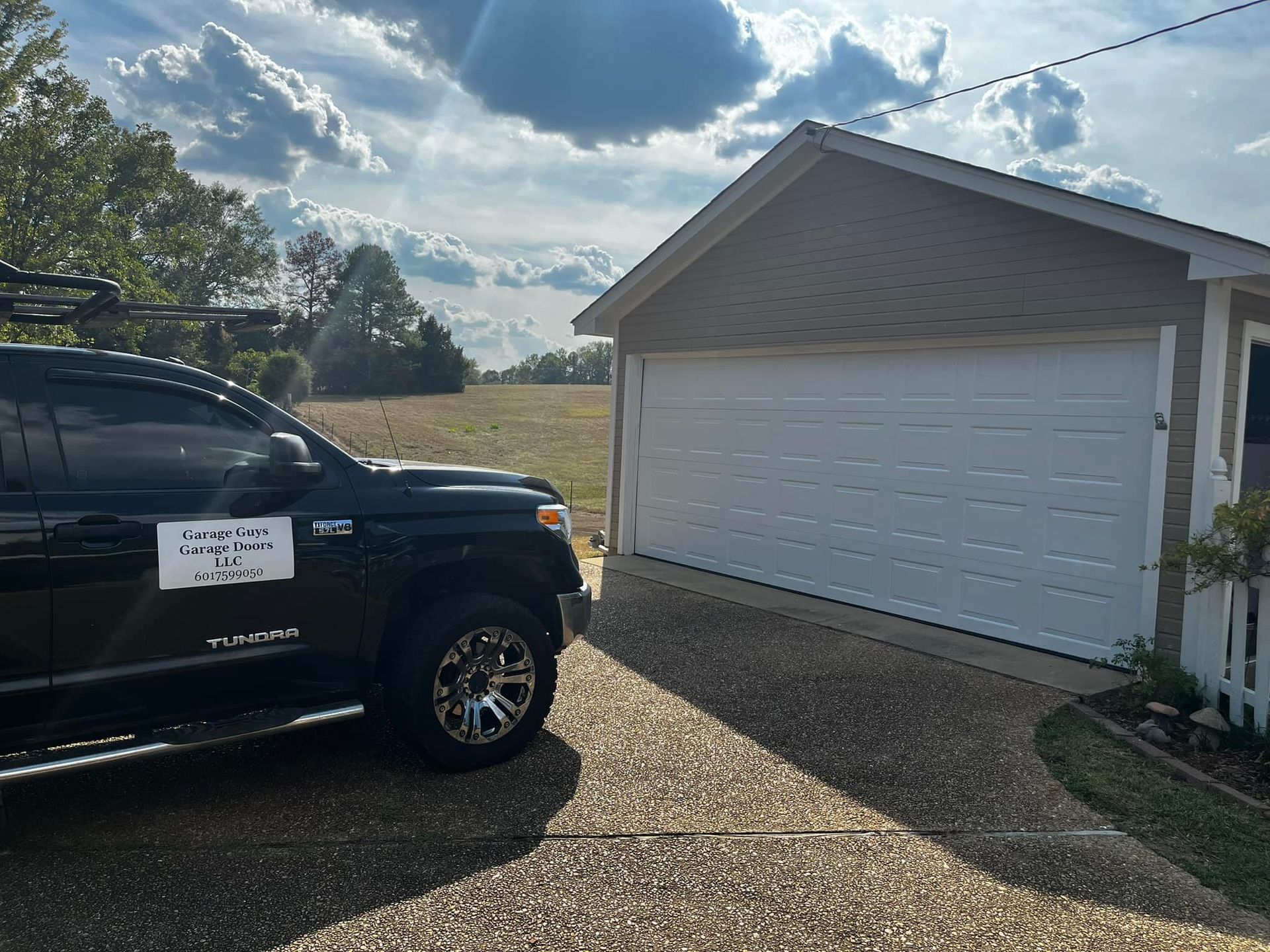A black truck is parked in front of a garage door.