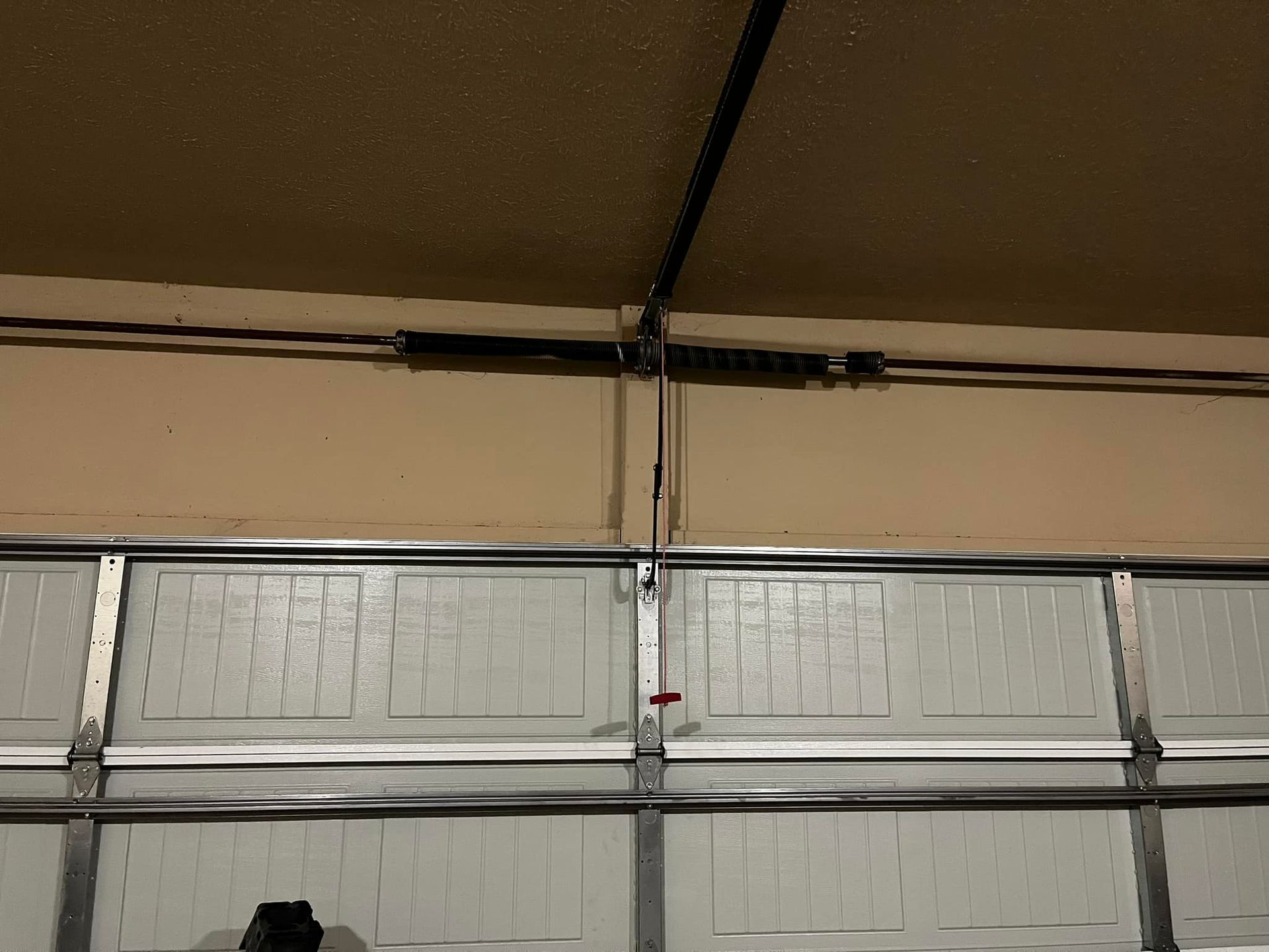 A close up of a garage door with a broken spring.