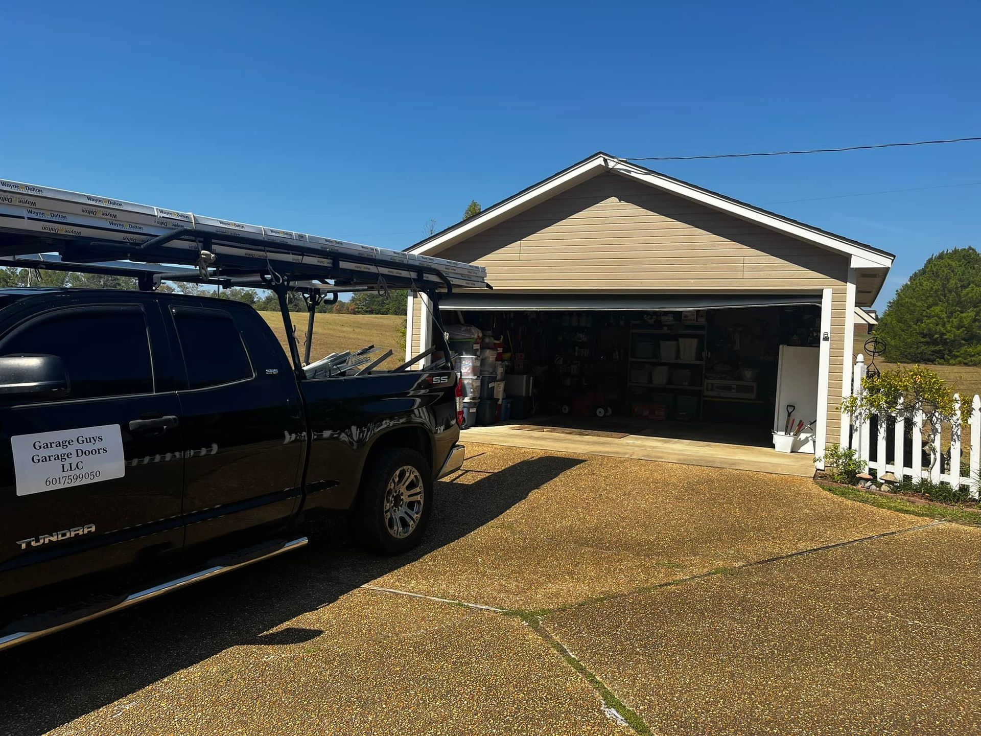 A black truck is parked in front of a garage.