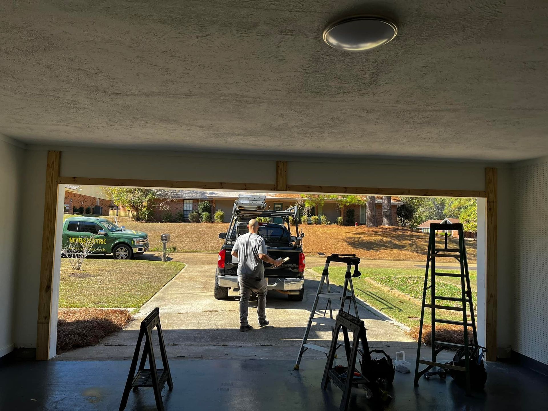 A man is standing in a garage next to a truck.