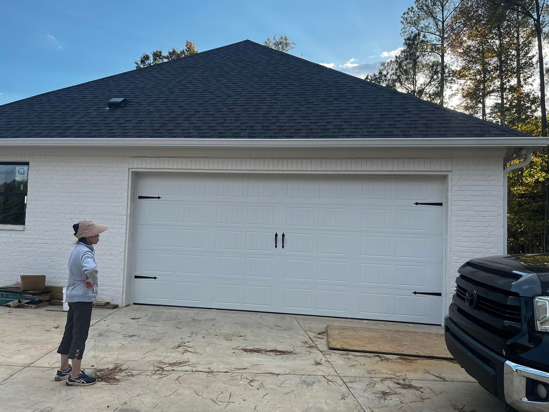 A man is standing in front of a white garage door.