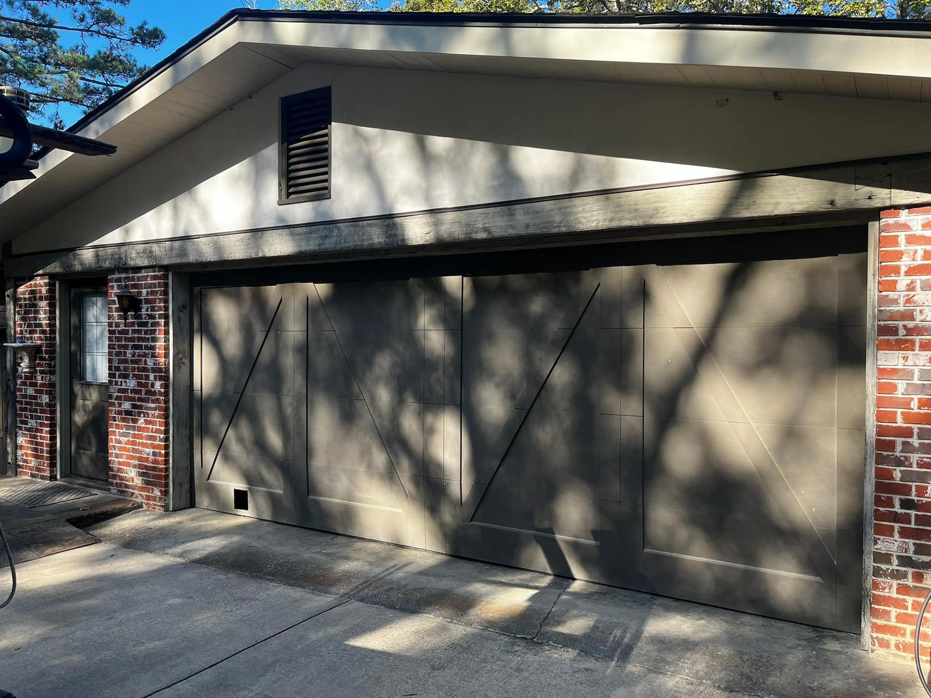A house with a garage door and a brick wall