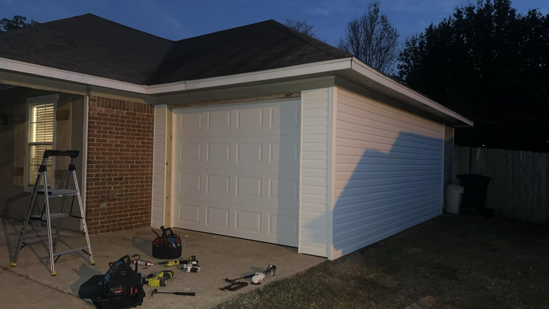 A garage door is being installed on the side of a house.